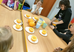 Dziewczynki po kolei wyciskają sok, przy użyciu ręcznej wyciskarki.