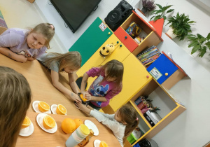 Dziewczynki po kolei wyciskają sok, przy użyciu ręcznej wyciskarki.