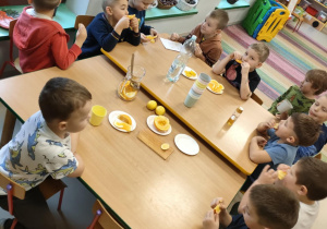 Chętni chłopcy częstują się pozostałymi plasterkami pomarańczy i cytrynki.