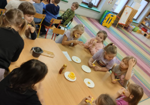 Chętne dziewczynki częstują się pozostałymi plasterkami pomarańczy i cytrynki.