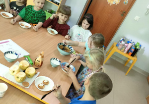 Na biszkopty układamy starte jabłka, odrobinę jogurtu naturalnego i odrobinę miodu, po czym próbujemy smaku "Szarlotki Misia Puchatka".