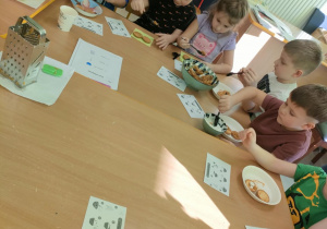 Na biszkopty układamy starte jabłka, odrobinę jogurtu naturalnego i odrobinę miodu, po czym próbujemy smaku "Szarlotki Misia Puchatka".