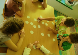 Młodsze dzieci bawią się wspólnie, przy użyciu sportowych memorków.