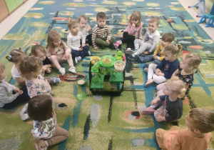 Dzieci obserwują chomika w klatce.