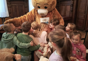 Dzieci z grupy "Motylków" przytulają się do Teddy Eddie.