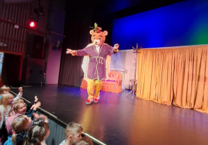 Dzieci stoją przed sceną po skończonym przedstawieniu.