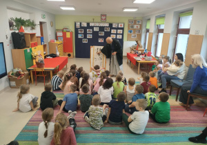 Pan Dariusz Szpakowski prezentuje dzieciom japoński obraz - kakemono.