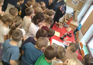 Przedszkolaki oglądają wystawę elementów kultury japońskiej, podczas gdy p. Dariusz omawia poszczególne przedmioty.
