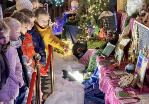 Dzieci z grupy "Motylków" podziwiają piękne prace konkursowe na VII Przeglądzie Tradycji Bożonarodzeniowych w kościele św. Józefa.