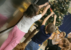 Stroimy naszą, klasową choinkę, wykorzystując drewniane zawieszki.