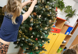 Ubieramy choinkę na pniu, wykorzystując kolorowe, plastikowe bombki o różnej wielkości.