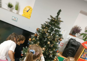 Ubieramy choinkę na pniu, wykorzystując kolorowe, plastikowe bombki o różnej wielkości.