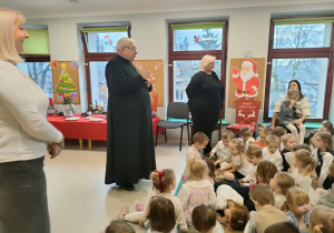 Ksiądz Zbigniew Kaczmarkiewicz rozmawia z dziećmi o zwyczajach świątecznych.