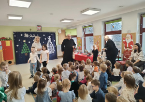 Starszaki wręczają przybyłym Gościom upominki.