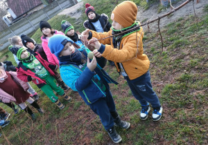 Spacerujemy po ogrodzie przedszkolnym i kolejno w parach przyczepiamy woreczki z pokarmem dla ptaków.