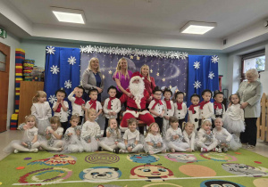 Wspólne, świąteczne zdjęcie pamiątkowe dzieci z grupy II wraz z Mikołajem.