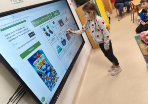 Dopasowujemy podpisy do zimowych obrazków na ekranie multimedialnym.