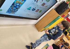 Dopasowujemy podpisy do zimowych obrazków na ekranie multimedialnym.