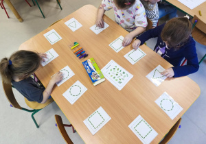 Ćwiczymy obie rączki jednocześnie, przesuwając kuleczki plasteliny po szablonach.