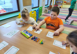 Ćwiczymy obie rączki jednocześnie, przesuwając kuleczki plasteliny po szablonach.