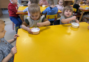 Dzieci przygotowują farbę z pianki do golenia i kleju.