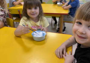 Dzieci przygotowują farbę z pianki do golenia i kleju.