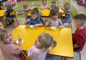 Dzieci przygotowują farbę z pianki do golenia i kleju.