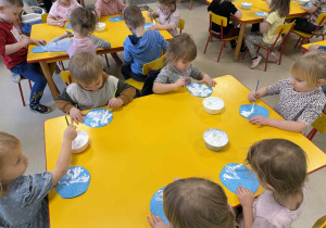 Dzieci malują śnieżynki z wykorzystaniem przygotowanej farby.