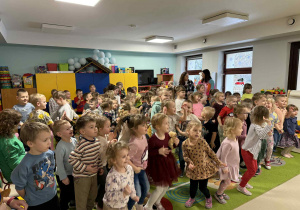Dzieci wspólnie tańczą do granej muzyki.