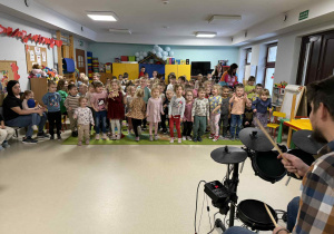 Dzieci wspólnie tańczą do granej muzyki.