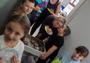 Delegacja z "Pszczółek" częstuje pysznymi pączkami pracowników kuchni.