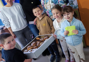 Delegacja z "Pszczółek" częstuje pysznymi pączkami pracowników Klubu Dziecięcego "Niedźwiadek".
