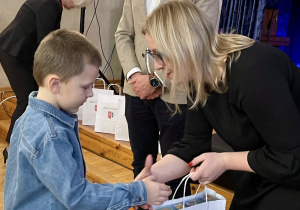Szymon Sowiński z grupy "Pszczółek" odbiera dyplom i nagrodę za zdobycie II miejsca w konkursie fotograficznym.