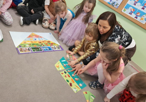 Dzieci z grupy "Żabek" układają piętra Piramidy Zdrowego Żywienia.