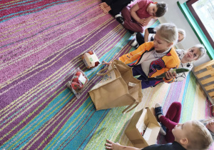 "Pszczółki" kolejno wyjmują produkty z ekologicznej torby.