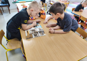 "Pszczółki" podczas pracy w grupie oglądają publikację pt. "Skąd się biorą produkty ekologiczne?"