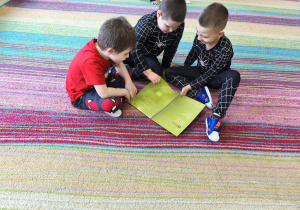 "Pszczółki" podczas pracy w grupie oglądają publikację pt. "Skąd się biorą produkty ekologiczne?"