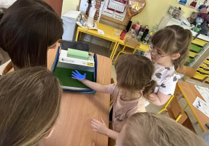 Zabawa badawcza z wykorzystaniem specjalistycznego narzędzia do szkolenia z zakresu higieny rąk ze światłem UV w grupie IV.