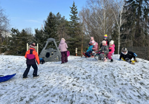 Dzieci bawią się na górce na ogrodzie przedszkolnym.