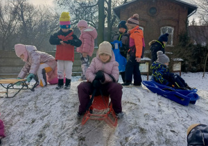 Dzieci bawią się na górce na ogrodzie przedszkolnym.