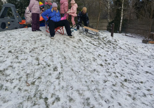 Dzieci bawią się na górce na ogrodzie przedszkolnym.