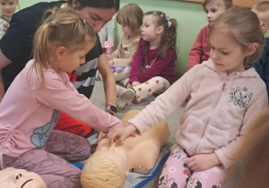 "Żabki" ćwiczą uciskanie klatki piersiowej na fantomie.
