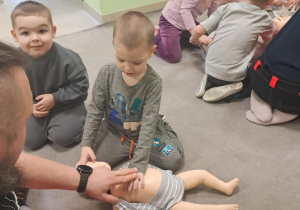 Dzieci z grupy "Żabek" ćwiczą uciskanie klatki piersiowej na małym fantomie.