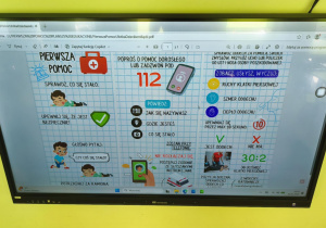 Plansza nt. udzielania pierwszej pomocy przedmedycznej, wyświetlona na dużym ekranie w grupie "Pszczółek".