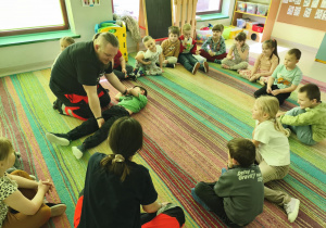 Prowadzący prezentuje pozycję bezpieczną w przypadku pacjenta nieprzytomnego, lecz oddychającego.