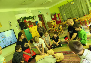 "Pszczółki" kolejno ćwiczą uciskanie klatki piersiowej na fantomie w obecności ratowników medycznych.