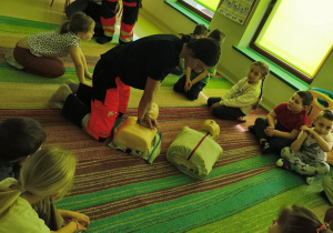 Prowadząca prezentuje przebieg resyscytacji krążeniowo-oddechowej w przypadku pacjenta, który nie oddycha.