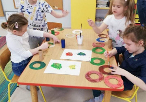 Kolorowanie farbami wyciętych kół ringo przez dzieci z "Kaczuszek"