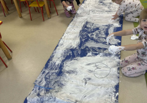 Dzieci tworzą kolejne elementy zimowego krajobrazu.