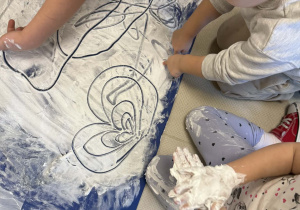 Dzieci tworzą kolejne elementy zimowego krajobrazu.